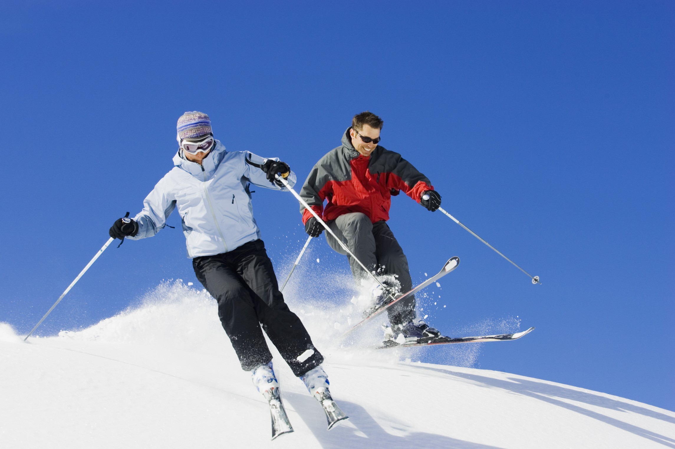 Couple downhill skiing